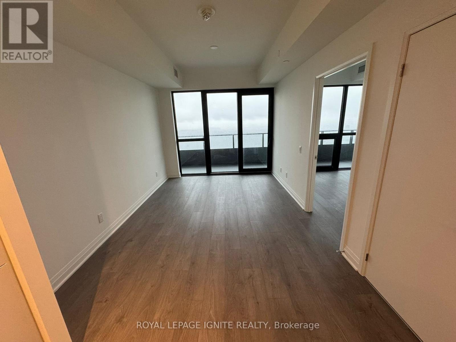 A room with wooden floors and a large window overlooking a bridge.