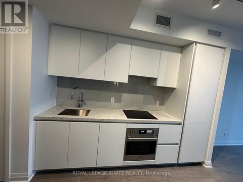 A modern kitchen with white cabinets and stainless steel appliances.