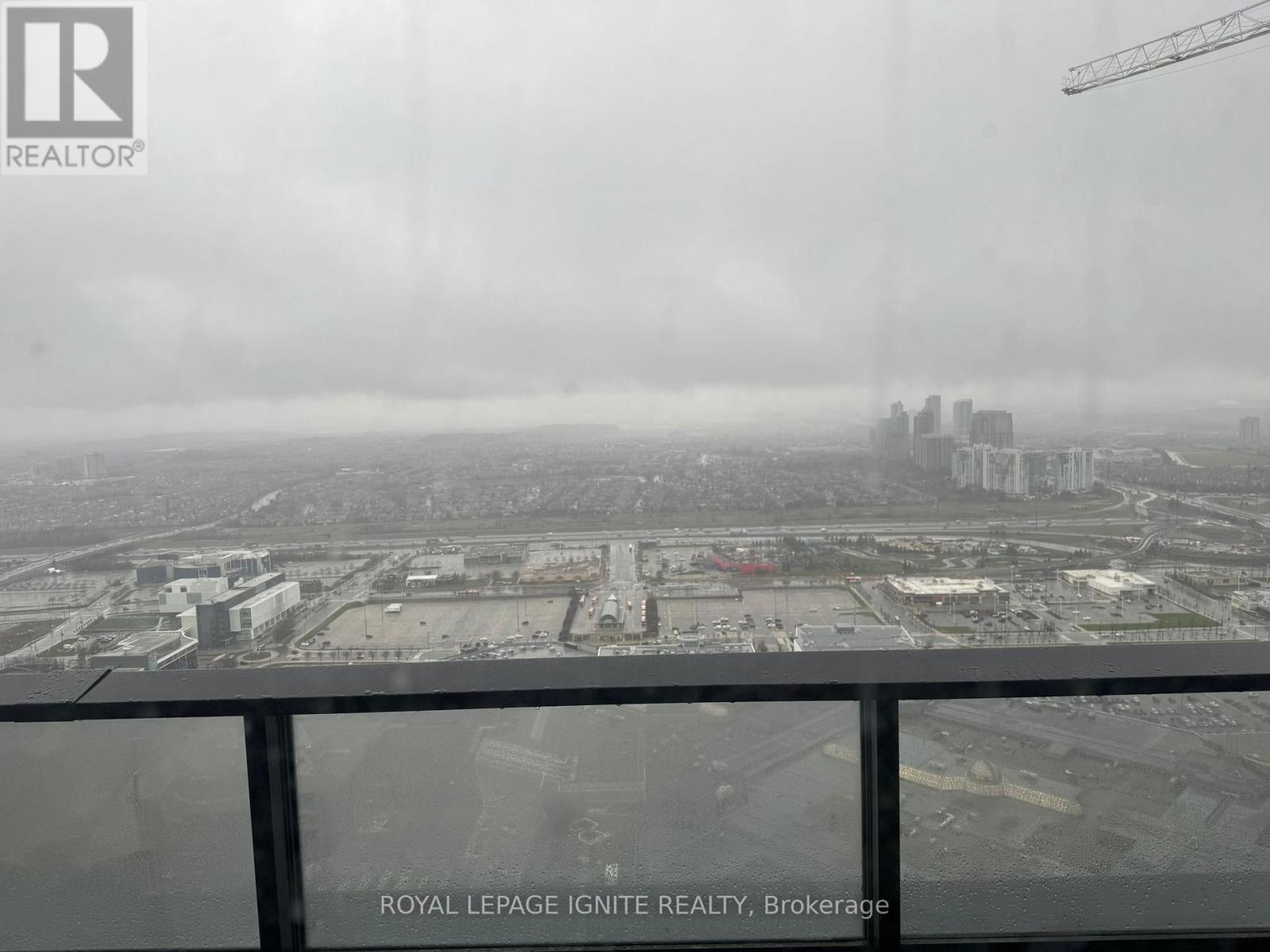A view from a high-rise building showing a cityscape with a construction site in the foreground.