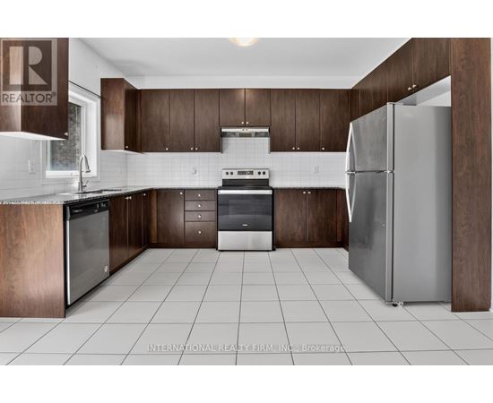A modern kitchen with dark wood cabinets and stainless steel appliances.