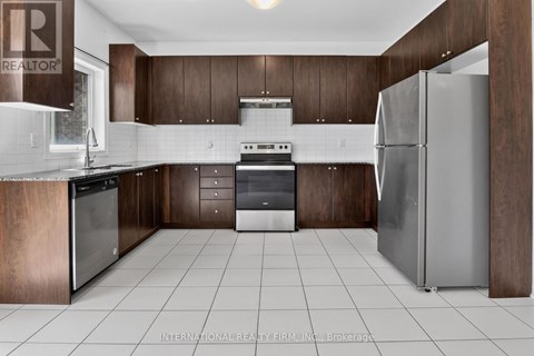 A modern kitchen with dark wood cabinets and stainless steel appliances.