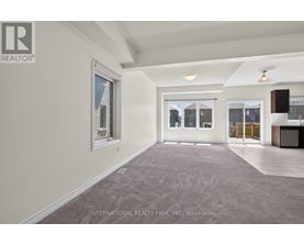 A spacious room with a carpeted floor and a large window.