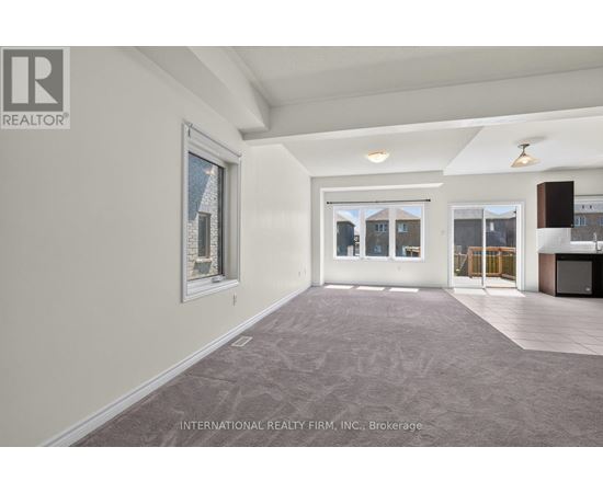 A spacious room with a carpeted floor and a large window.