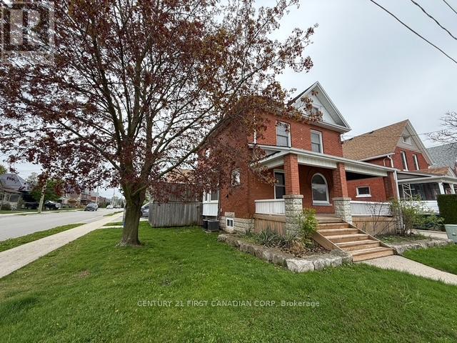 A brick house with a tree in front of it.