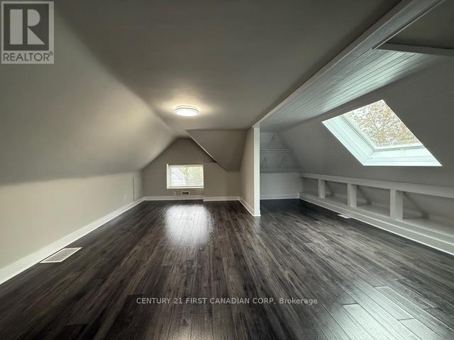 A spacious room with wooden floors and skylights.