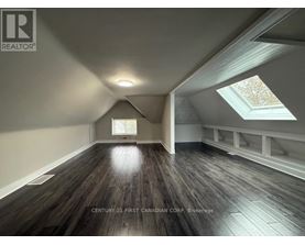 A spacious room with wooden floors and skylights.