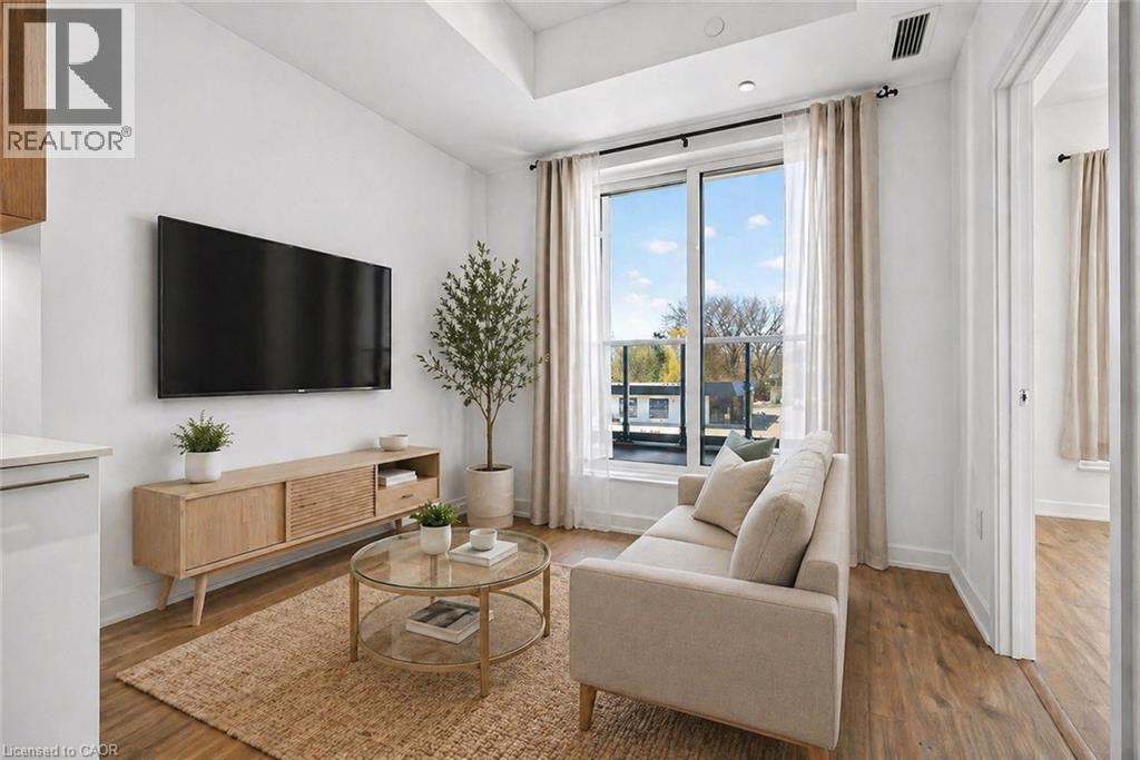 A living room with a flat screen TV mounted on the wall above a wooden cabinet.