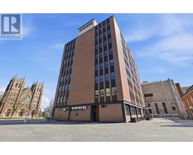 A tall building with a glass facade is the main focus of the image.