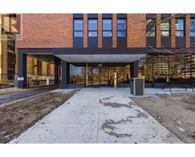 A modern building with a brick facade and a large glass entrance.