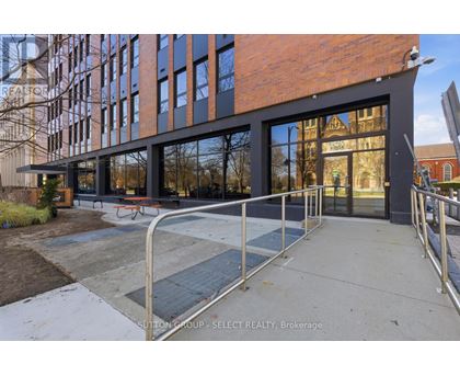 A modern building with a glass facade and a metal railing in front.
