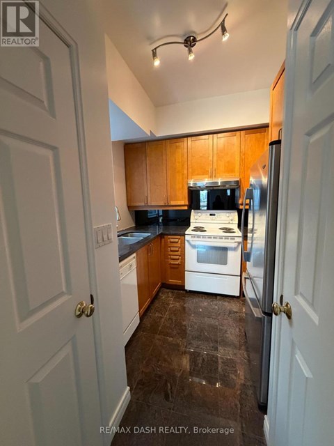 A kitchen with wooden cabinets and a white fridge.