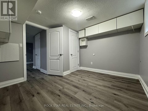 A room with wood flooring and white walls.