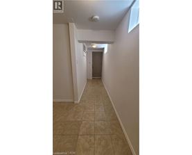 A hallway with tiled flooring and white walls.