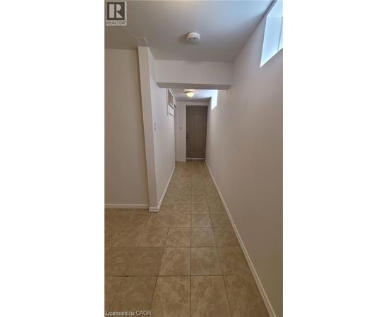 A hallway with tiled flooring and white walls.