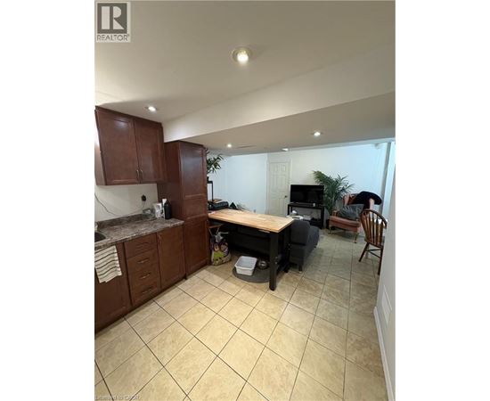 A kitchen with brown cabinets and a tiled floor.