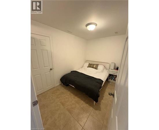 A bedroom with a bed, nightstand, and door.