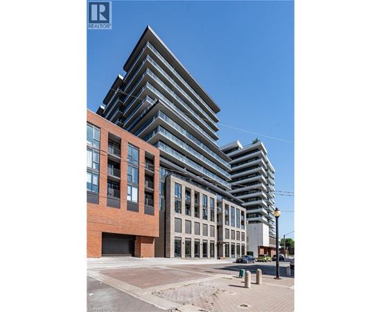 A modern multi-story building with a glass facade is under construction.