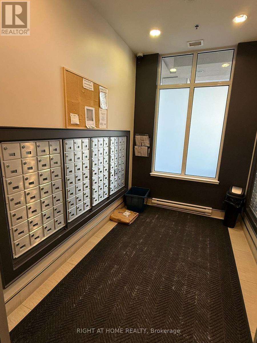 A hallway with a carpeted floor and mailboxes on the wall.