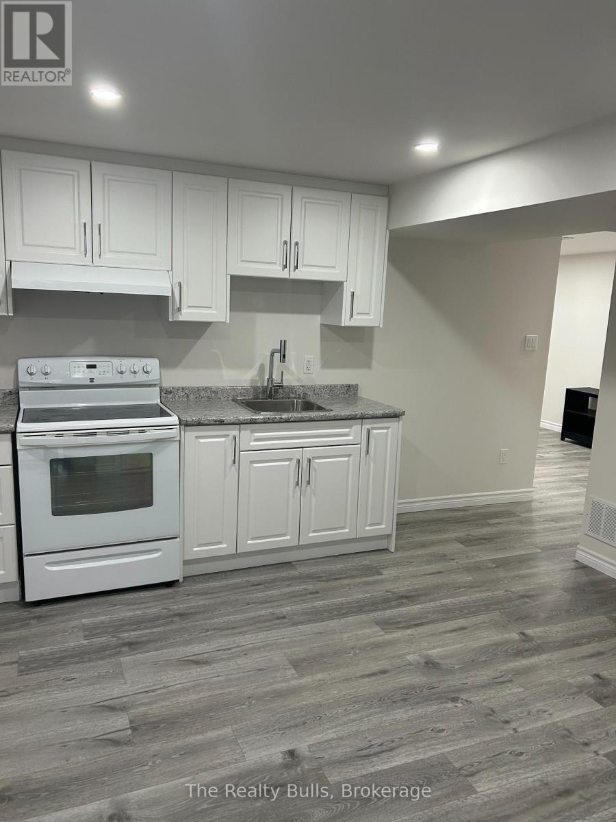 A kitchen with white cabinets and a stove top oven.