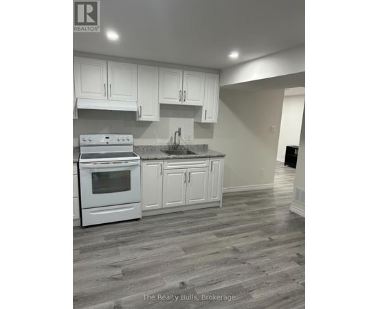 A kitchen with white cabinets and a stove top oven.