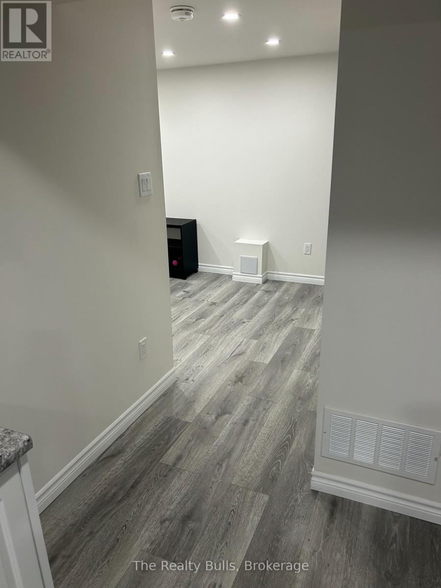 A room with a wooden floor and a white wall.