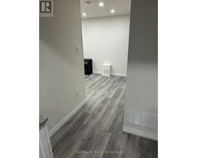 A room with a wooden floor and a white wall.