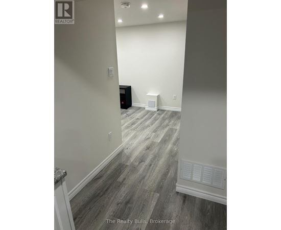 A room with a wooden floor and a white wall.