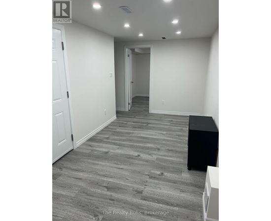 A hallway with a black box on the floor and a white door on the left.