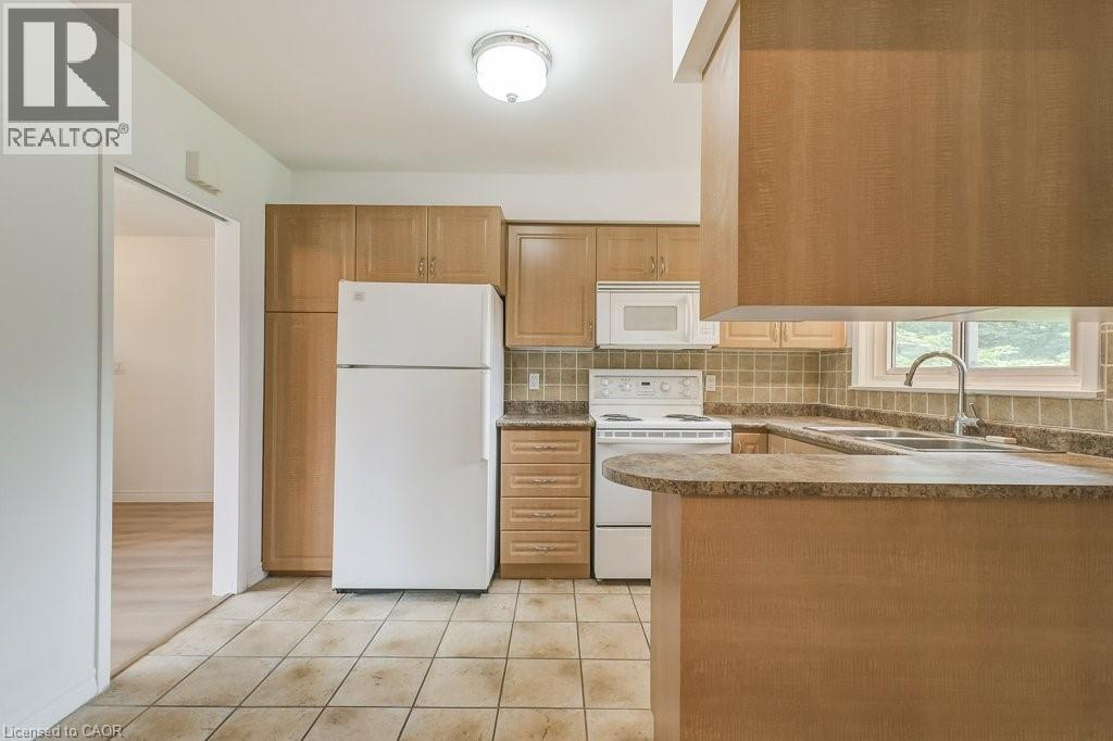 A kitchen with a white fridge and brown cabinets.
