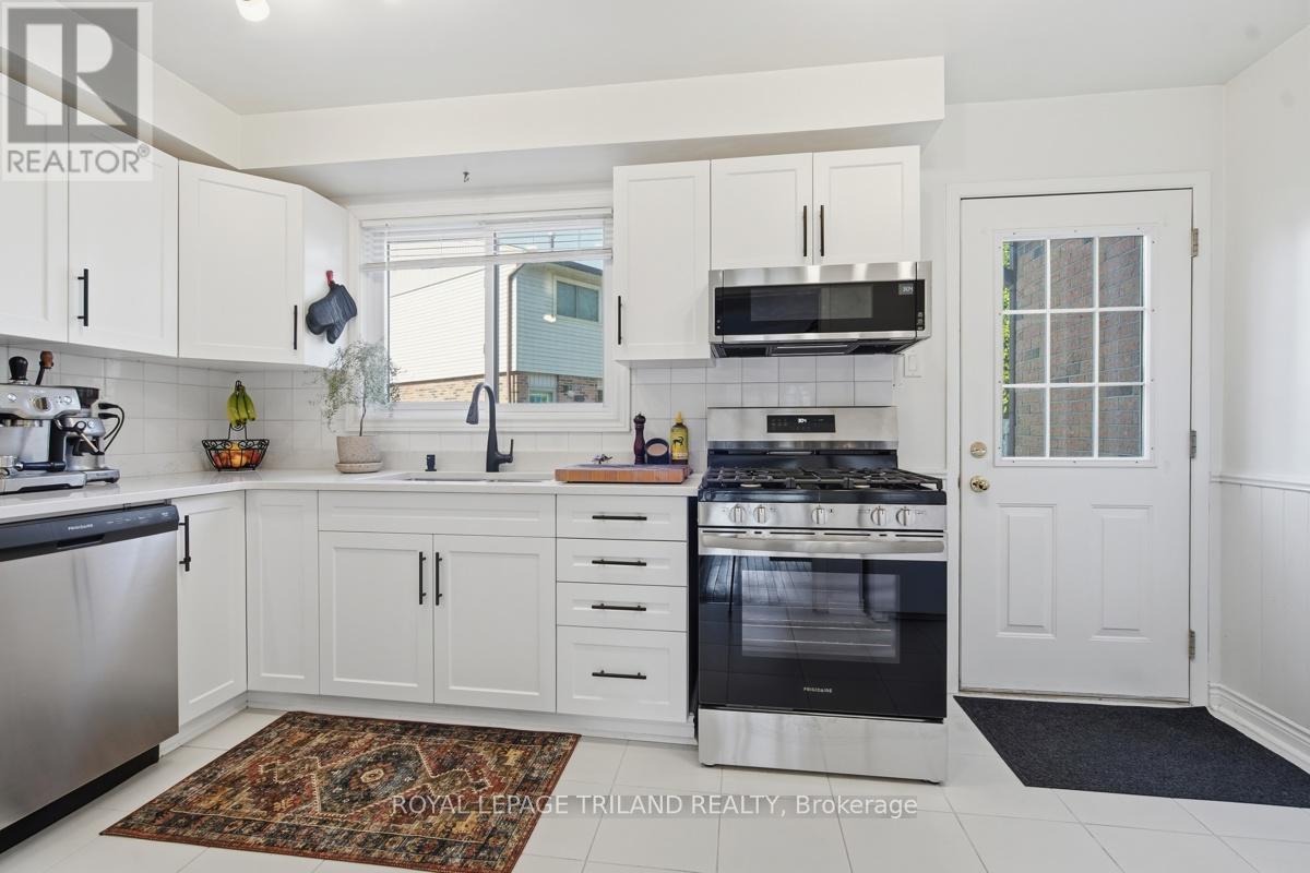 A kitchen with white cabinets and a rug on the floor.