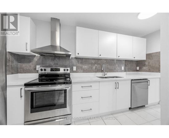 A modern kitchen with a stove, sink, and cabinets.