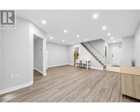 A spacious room with a staircase and a dining table.