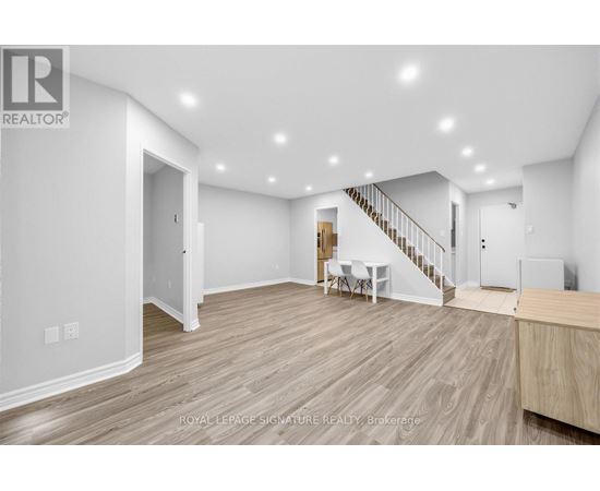 A spacious room with a staircase and a dining table.