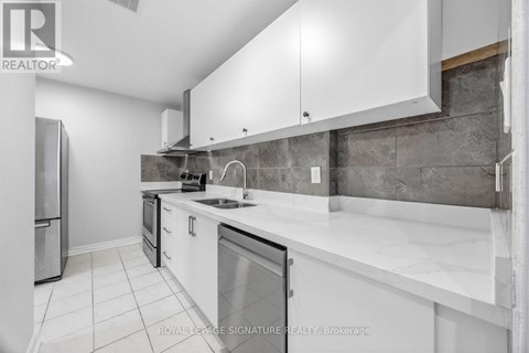 A modern kitchen with white cabinets and a marble countertop.
