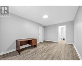 A room with a wooden table and light grey walls.