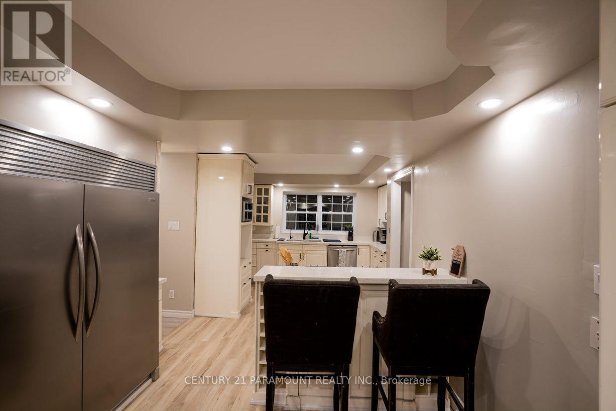 A kitchen with a refrigerator, table and chairs.