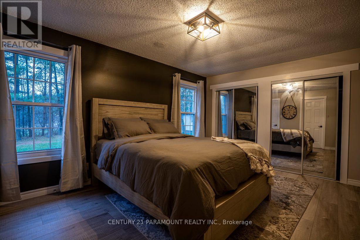 A bedroom with a large bed and a window with curtains.