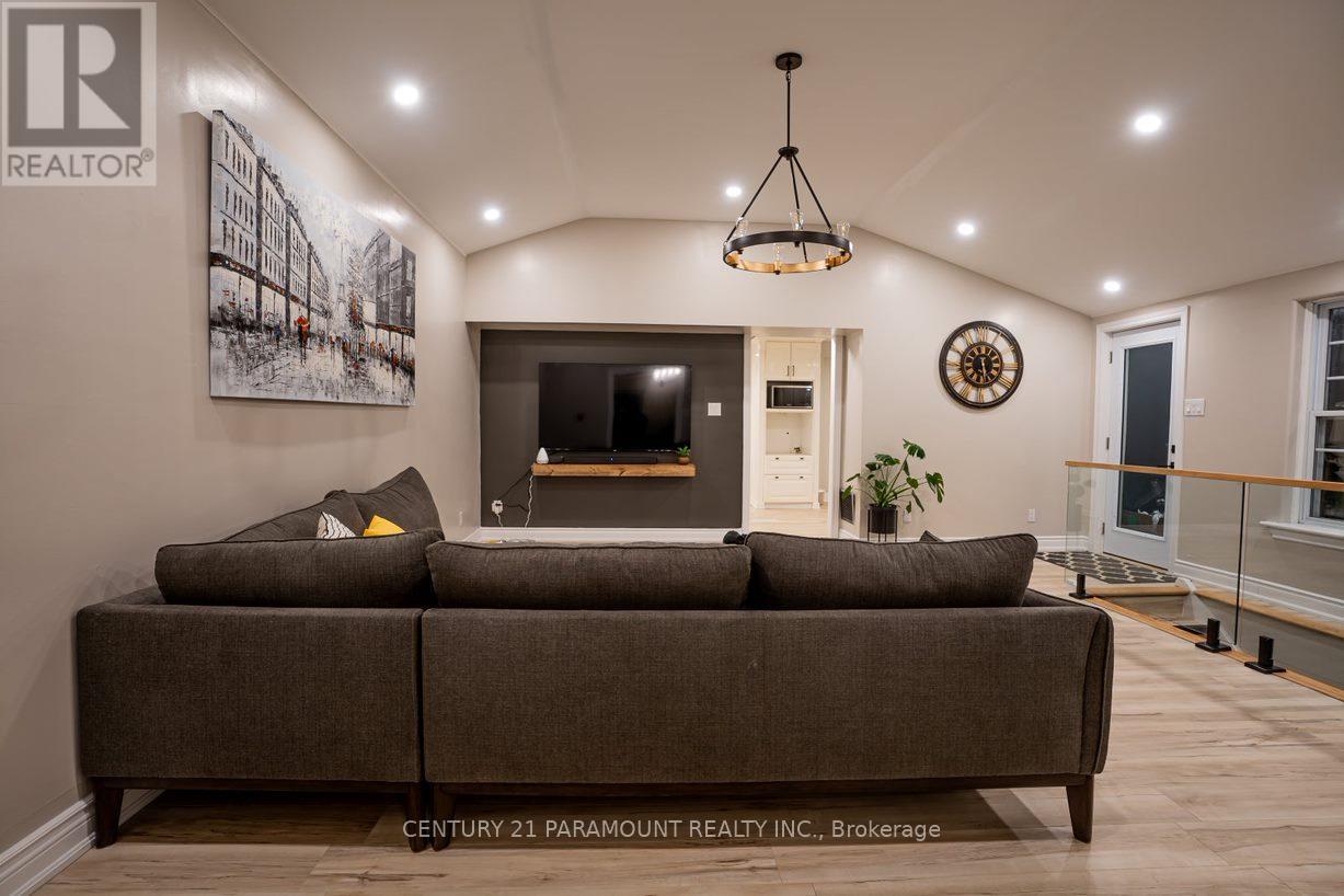 A living room with a brown couch and a painting on the wall.