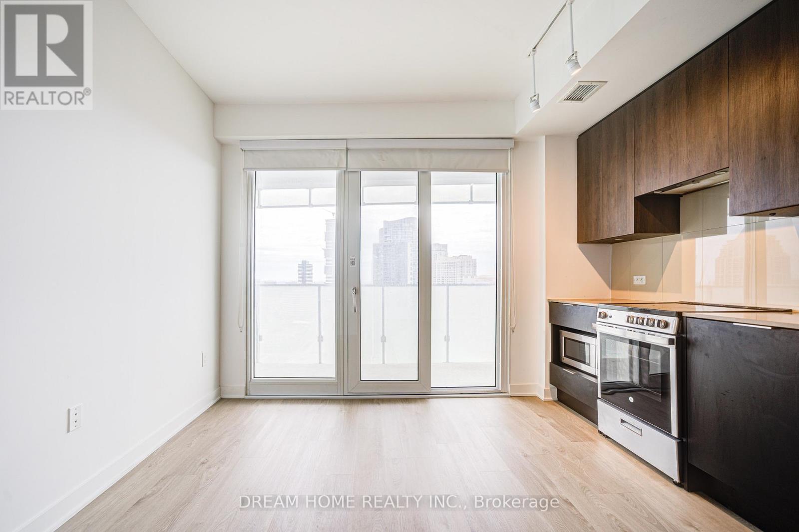 A modern kitchen with a stainless steel oven and wooden cabinets.