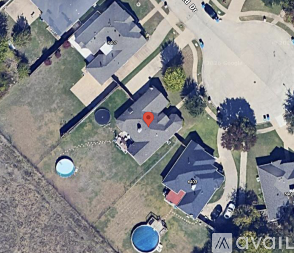 A bird's eye view of a neighborhood with houses and a pool.