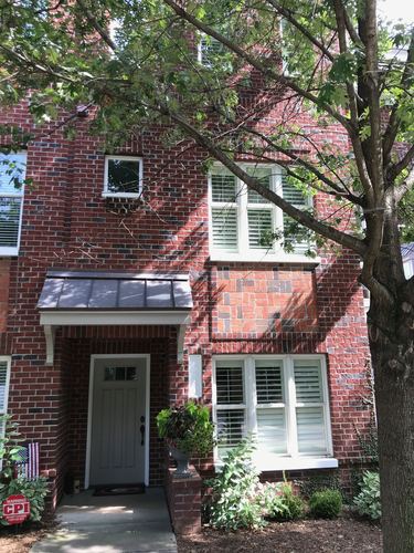 A red brick house with a white door and window.