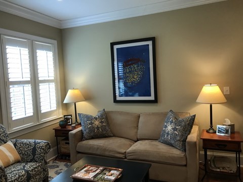 A living room with a couch, chair, and table with lamps.