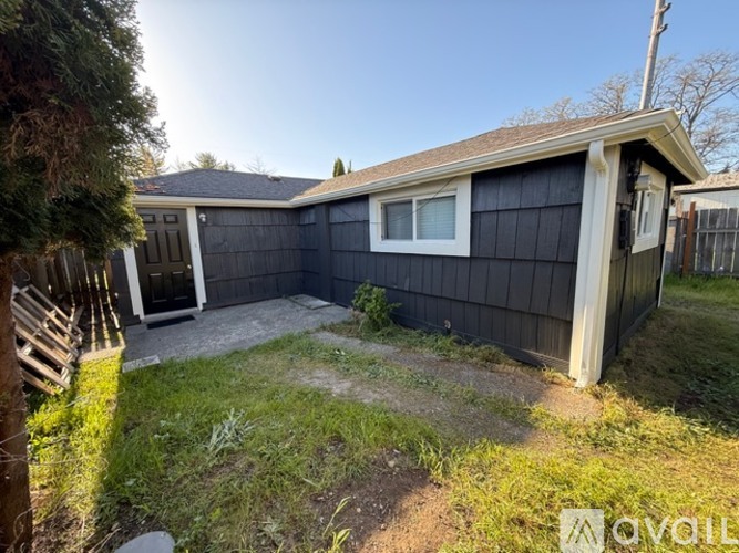 A black house with a white window and a brown door.