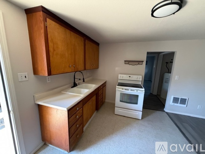 A kitchen with wooden cabinets and a white sink.