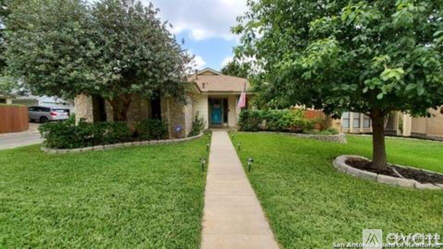 A house with a green lawn and a tree in front.