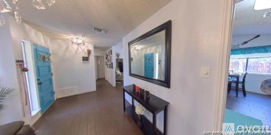 A long hallway with a mirror on the wall.