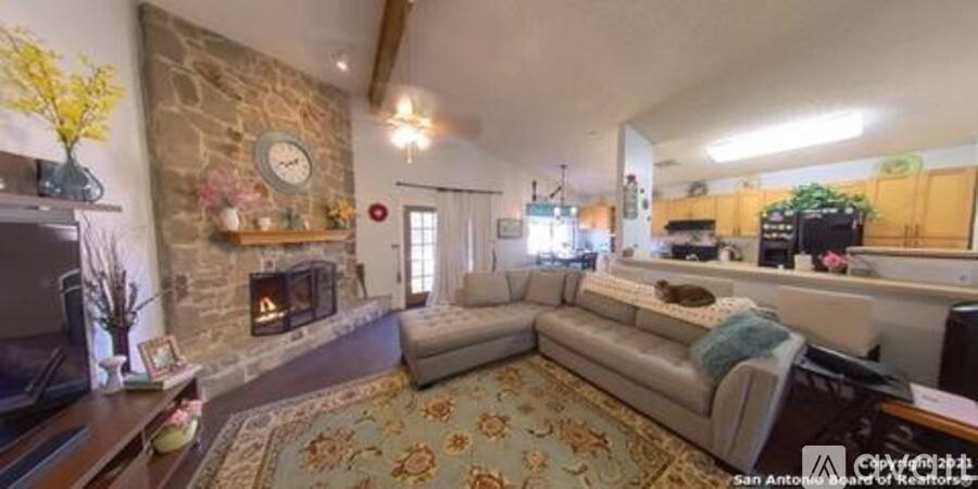 A living room with a stone fireplace and a couch.