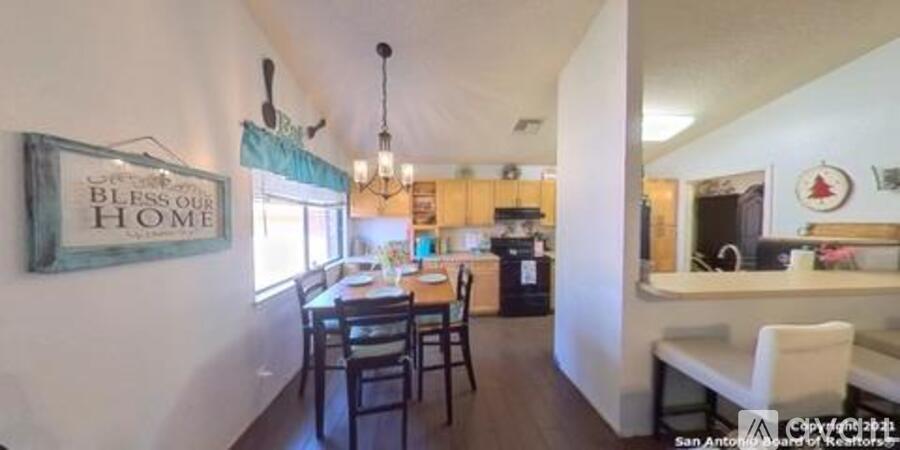 A kitchen with a dining table and chairs in the middle of the room.