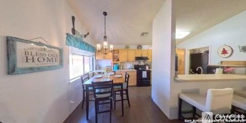 A kitchen with a dining table and chairs in the middle of the room.