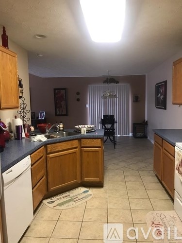 A kitchen with wooden cabinets and a white dishwasher.